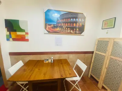 a wooden table and chairs next to a wall with a painting at ROMA GONDOLA SRLS in Rome