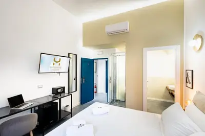 a room with a white bed and a laptop on a desk at Fastime in Rome