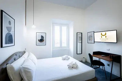 a white bedroom with a bed and a desk at Fastime in Rome
