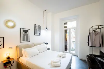 a white bedroom with a bed and a window at Fastime in Rome