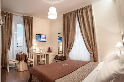 a bedroom with a bed and a desk and a window at Al Relais in Rome