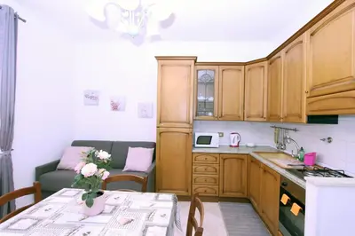 a kitchen with wooden cabinets and a table with flowers on it at Torrigio Flat in Rome