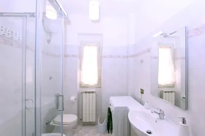 a white bathroom with a sink and a toilet at Torrigio Flat in Rome