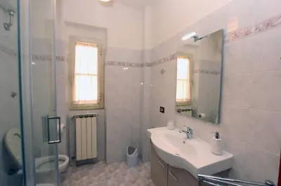 a white bathroom with a sink and a mirror at Torrigio Flat in Rome