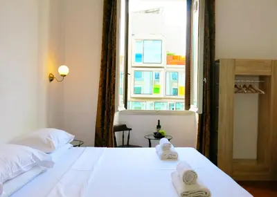 a bedroom with a white bed and a window at NIK Rooms in Rome