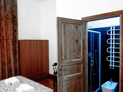 a room with a bed and a door to a shower at NIK Rooms in Rome
