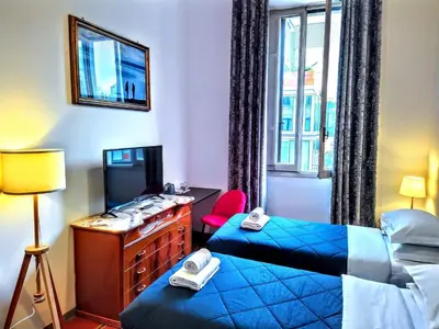 a hotel room with two beds and a television at NIK Rooms in Rome