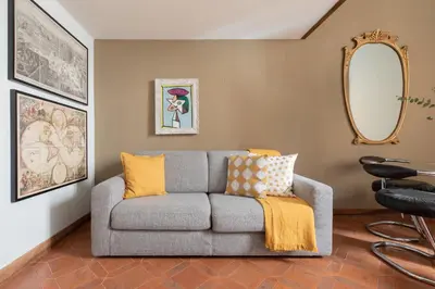 a living room with a gray couch with yellow pillows at iFlat Pantheon Historic Two-Story Apartment in Rome