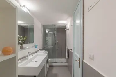 a white bathroom with two sinks and a shower at iFlat Pantheon Historic Two-Story Apartment in Rome