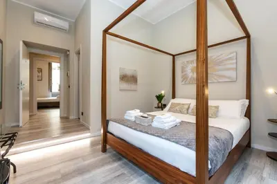 a bedroom with a canopy bed with white sheets at Suites 44 - Guesthouse close to Vaticano, San Pietro, Castel Sant'angelo in Rome