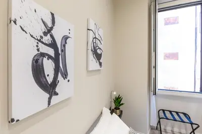 a bedroom with black and white art on the wall at Suites 44 - Guesthouse close to Vaticano, San Pietro, Castel Sant'angelo in Rome