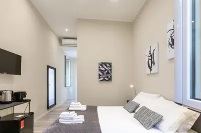 a white room with a bed and a tv at Suites 44 - Guesthouse close to Vaticano, San Pietro, Castel Sant'angelo in Rome