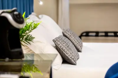 a bed with two pillows on it with a glass table at Suites 44 - Guesthouse close to Vaticano, San Pietro, Castel Sant'angelo in Rome