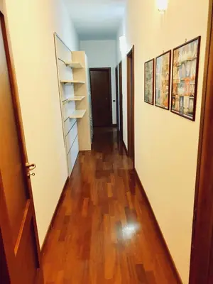 a hallway of an apartment with wooden floors and shelves at Comfort spazio e privacy 2 camere 2 bagni e self check in nel cuore di San Giovanni in Rome