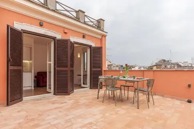 a patio with a table and chairs on a building at Apartment with Terrace in via del Pellegrino - FromHometoRome in Rome