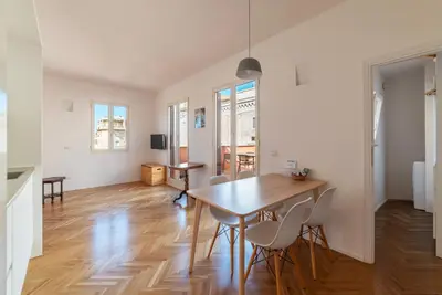 a dining room and living room with a table and chairs at Apartment with Terrace in via del Pellegrino - FromHometoRome in Rome