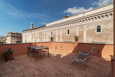 a patio with a table and chairs on a roof at Apartment with Terrace in via del Pellegrino - FromHometoRome in Rome