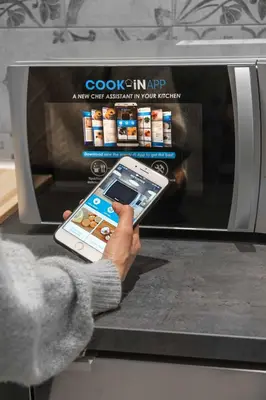 a person holding a cell phone in front of an oven at Corso 101 in Rome