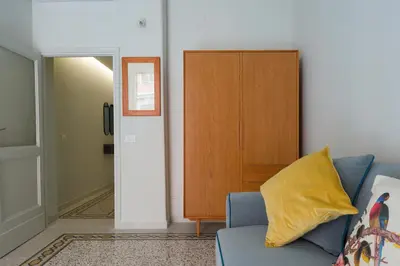 a living room with a blue couch and a wooden cabinet at Casa Satrico in Rome