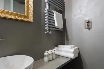 a bathroom with a white toilet and towels on a shelf at Casa Satrico in Rome