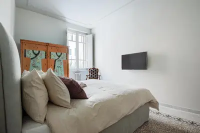 a bedroom with a bed with a television on the wall at Casa Satrico in Rome