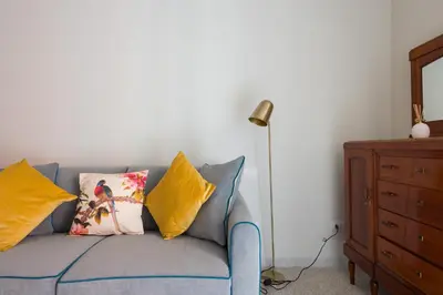 a blue couch with yellow pillows and a lamp at Casa Satrico in Rome