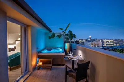 a room with a tub and a bed on a balcony at Hotel St Martin by OMNIA hotels in Rome