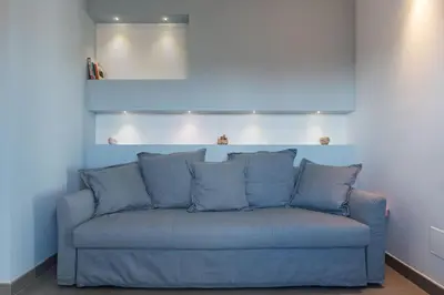 a blue couch sitting in a living room at GuestHost - Piazza Navona Panoramic Penthouse in Rome