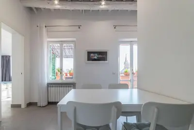 a white dining room with a white table and chairs at GuestHost - Piazza Navona Panoramic Penthouse in Rome
