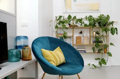 a blue chair with a yellow pillow on a desk at RENOVATED AND COZY FLAT in Rome