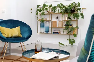 a living room with a blue chair and a glass table at RENOVATED AND COZY FLAT in Rome