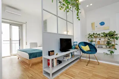 a bedroom with a bed and a tv and a chair at RENOVATED AND COZY FLAT in Rome