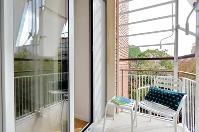 a white chair with a blue pillow sitting on a balcony at RENOVATED AND COZY FLAT in Rome
