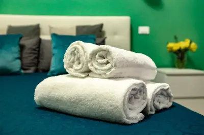 a pile of towels sitting on top of a bed at Lydka Domus in Rome