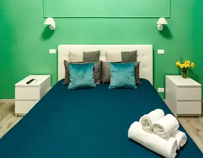 a bedroom with a large blue bed with towels on it at Lydka Domus in Rome