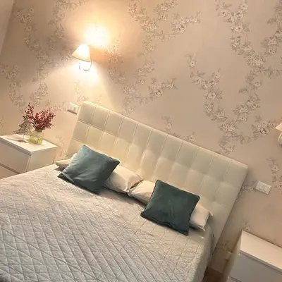 a bedroom with a bed with two green pillows at Lydka Domus in Rome