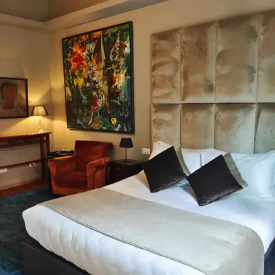 a hotel room with a large bed and a chair at Ada Home in Rome