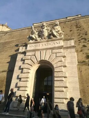 a group of people walking around a building with an arch at Chiaretta Guest House in Rome