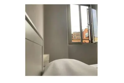 a mirror in a room with a window and a bed at Chiaretta Guest House in Rome