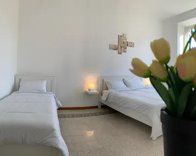 a bedroom with two beds and a vase of flowers at Chiaretta Guest House in Rome