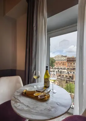 a table with two glasses and a bottle of wine at Torre Argentina Relais - Residenze di Charme in Rome