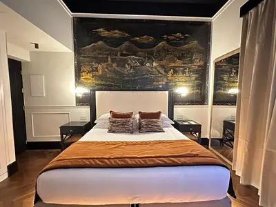 a bedroom with a large bed with two pillows on it at Torre Argentina Relais - Residenze di Charme in Rome