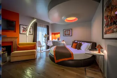 a bedroom with a bed and a desk and a chair at Torre Argentina Relais - Residenze di Charme in Rome