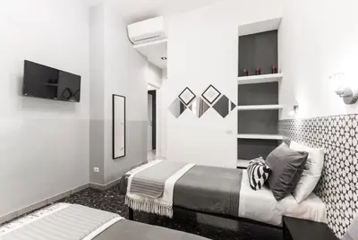 a hotel room with two beds and a tv at Benincasa Bed&Breakfast in Rome