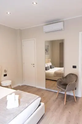 a bedroom with a mirror and a bed and a chair at XXIV Domus Luxury Suites in Rome