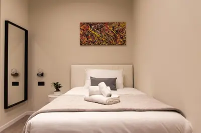 a bedroom with a bed with a painting on the wall at XXIV Domus Luxury Suites in Rome