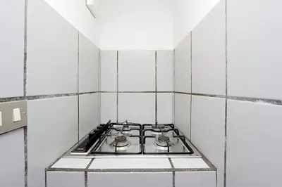a stove top oven in a white tiled kitchen at Welcome to Trastevere in Rome