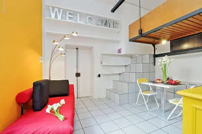 a living room with a red couch and a kitchen at Welcome to Trastevere in Rome