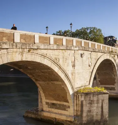 a bridge over the water with a man standing on it at Welcome to Trastevere in Rome