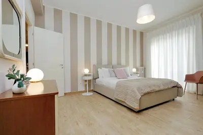 a bedroom with a bed and a striped wall at Elegant 3-Bed Apartment 10' Termini Wi-Fi AC in Rome